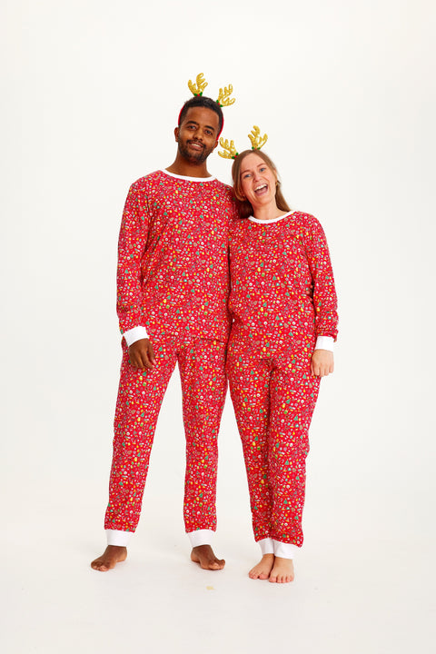 En mand og en kvinde er iført en rød julepyjamas med mønster på.