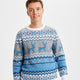 En smilende mand iført en blå julesweater med rensdyr på.