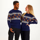 En mand og en dame iført en blå julesweater med rensdyr på.